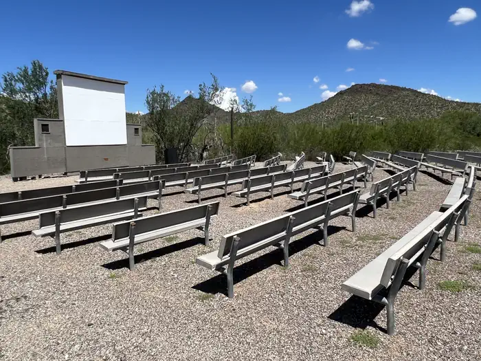 TWIN PEAKS CAMPGROUND — A photo of the amphitheater at TWIN PEAKS CAMPGROUND, with many benches and a screen.