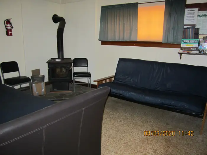 Barber Flat Cabin (Boise National Forest, ID) — A wood stove with two futons couch-beds in a living room.