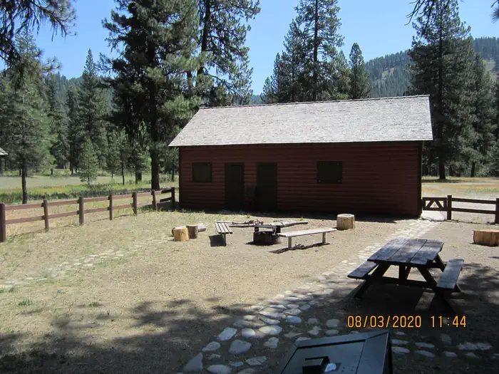 Barber Flat Cabin (Boise National Forest, ID) — A fenced yard with a campfire ring and picnic tables.