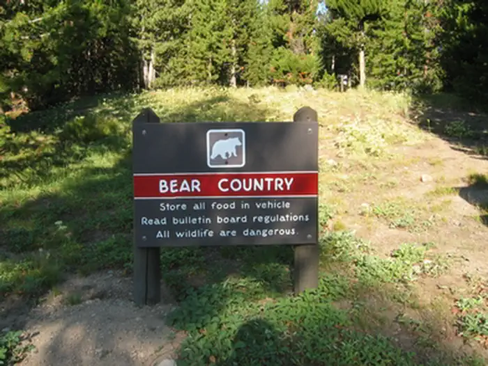 Indian Creek Campground (Yellowstone) — A campground sign warns, "Bear Country: Store all food in vehicle. Read bulletin board regulations. All wildlife are dangerous." Also visit https://www.nps.gov/yell/planyourvisit/safety.htm