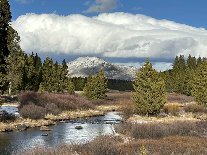 Indian Creek Campground (Yellowstone) — Bunsen Peak under cumulus clouds with a creek in the foreground. The trailhead for Bunsen Peak is not far from Indian Creek Campground