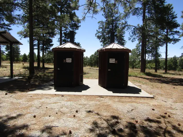Ponderosa Group Campground (NM) — Vault toilets in front of tall pines
