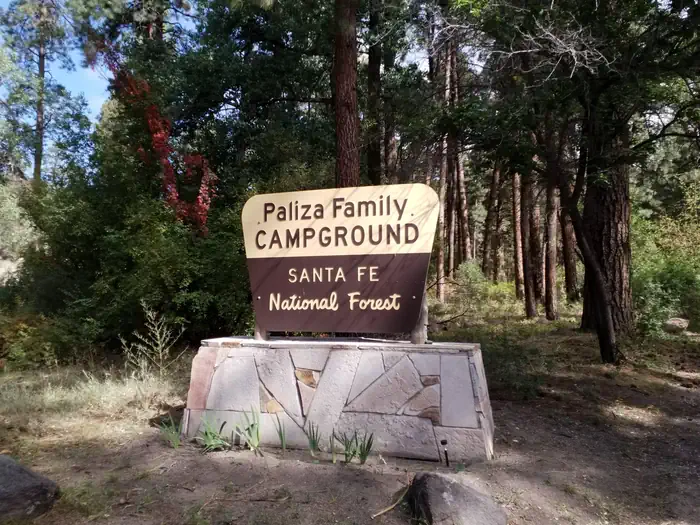 Paliza Campground — The entrance sign of Paliza Family campground surrounded by pines in the background.