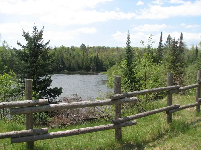 Au Sable Loop Campground & Day Use Area — A view of the Au Sable River and a fence from the Au Sable Loop Day Use Area