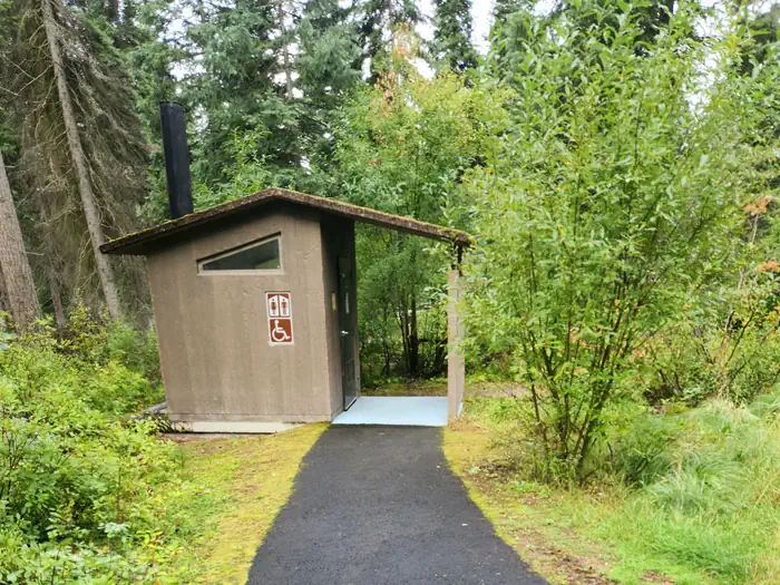 Lake Alva Campground — A photo of a Lake Alva Campground vault toilet. There is a paved, accessible walkway.