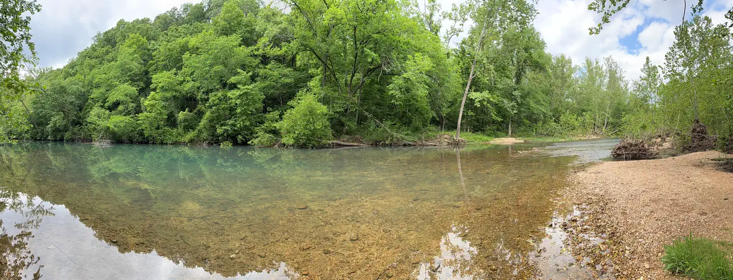 Lane Spring Recreation Area — A view of Little Piney Creek, waterway in front with green vegatation in the background