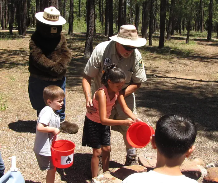 Spillway (az) — Smokey Bear oversees as children learn how to extinguish a campfire
