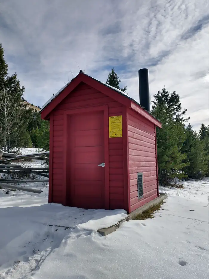 High Rye Cabin — Red Outhouse, Surrounded by snow and green trees