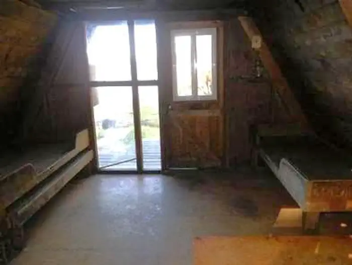 Garnet Ledge Cabin — Interior of wood cabin with two wood bunkbeds, window and door