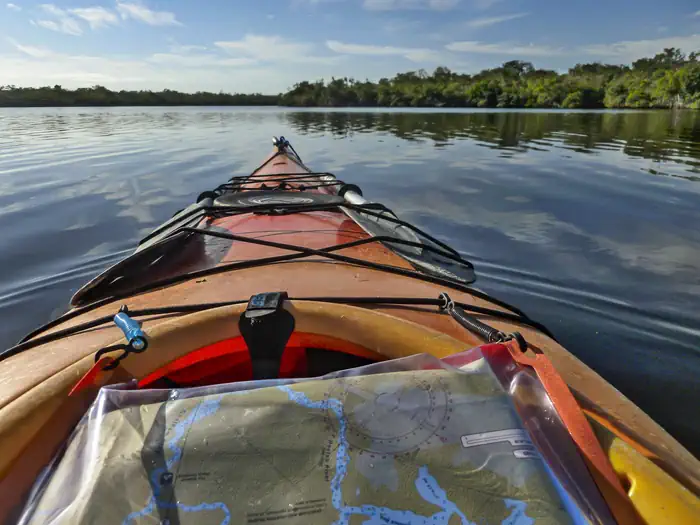 Everglades Backcountry Wilderness Camping Permits — Looking towards the bow of an orange kayak. Water and trees in the background.
