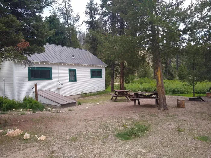 Beaver Creek Cabin (id) β A cabin next to picnic tables and a fire ring.