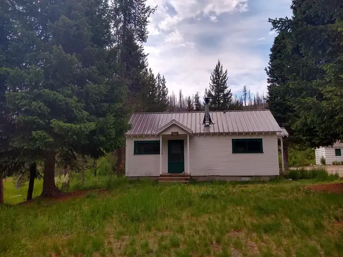 Beaver Creek Cabin (id) β A small white cabin in a green field.