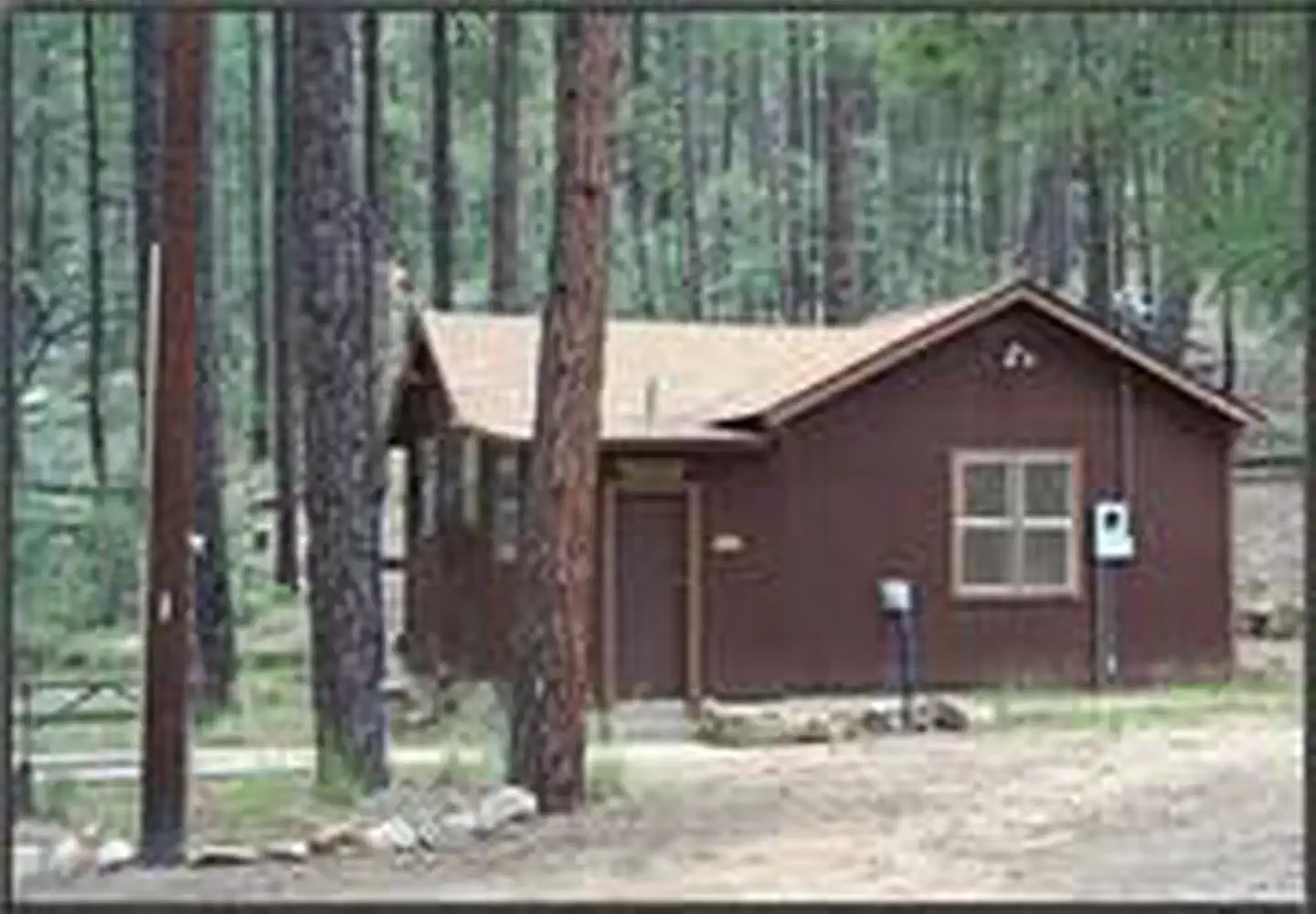 Horsethief Cabin — Exterior of Horsethief cabin sitting in the ponderosa with picnic table to the left