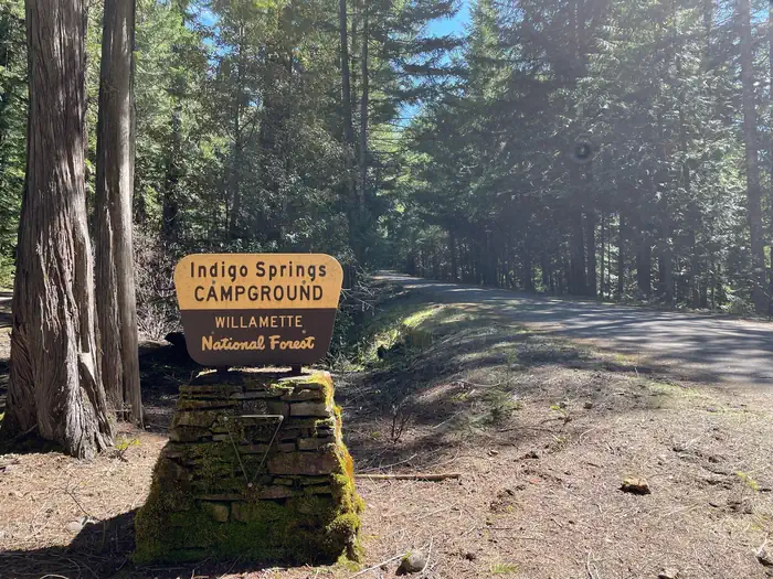 Indigo Springs Campground — A cream and brown sign on a stone pedestal. The sign reads "Indigo Springs Campground"