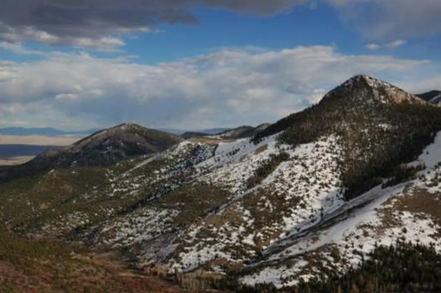 Grey Cliffs Campground — Mountains with patchy snow under blue sky