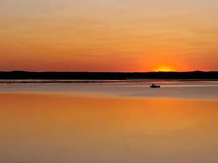 Hazelton Recreation Area — A lone boat out fishing on Lake Oahe at sunset at Hazelton Recreation Area