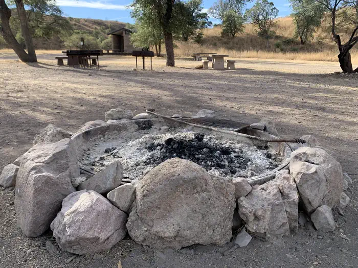 Calabasas — A stone-ringed fire pit on the ground with dark ashes in the center.