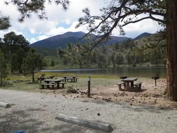 Ohaver Lake Campground — Picnic tables near lake with mountains in background