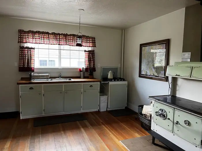 Cowpuncher Guard Station β Kitchen with wood cookstove, propane cooktop and kitchen sink