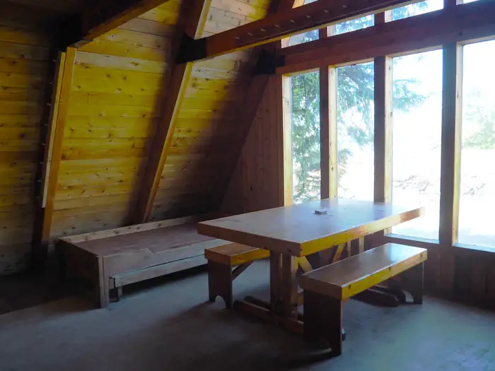 Steamer Bay Cabin — Inside of Steamer Bay cabin with table, benches, and bunks.