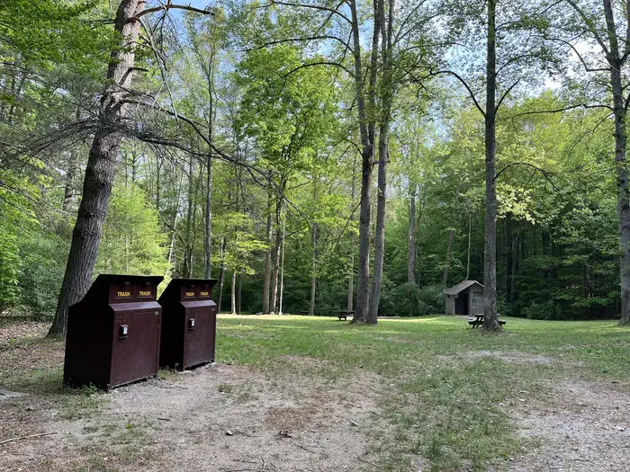Hopper Creek Group Camp — A large grassy field with two brown trash cans on the left