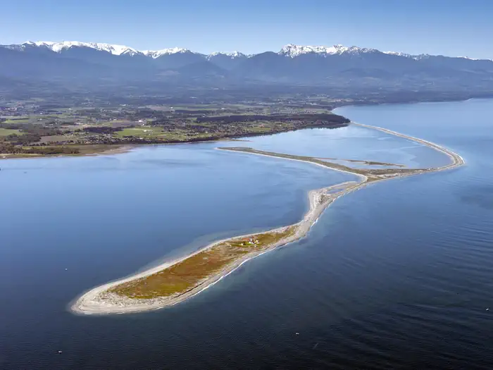 Dungeness National Wildlife Refuge — A long, narrow spit of land extends from the mainland into the ocean with mountains in the background.