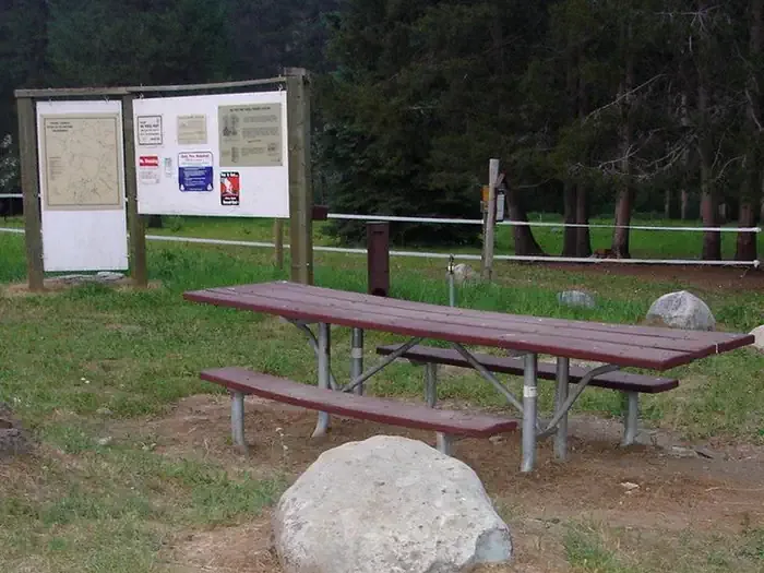Payette National Forest Big Creek Campground: Picnic table with kiosk in background.
