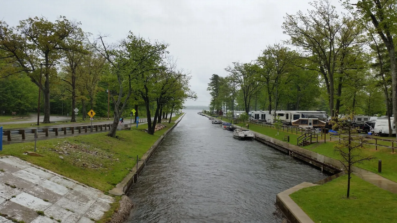 Canal between lakes lined with grass and trees