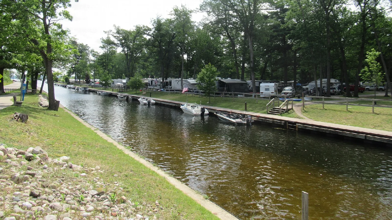 Narrow canal with docks and campsites along the bank