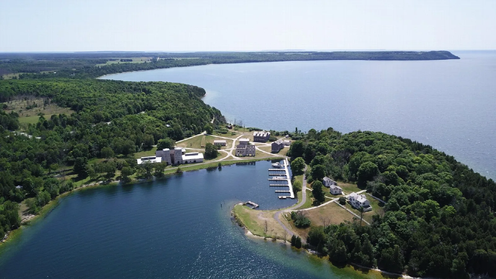 Aerial view of a harbor, small boat basin and wooded point on Lake Michigan