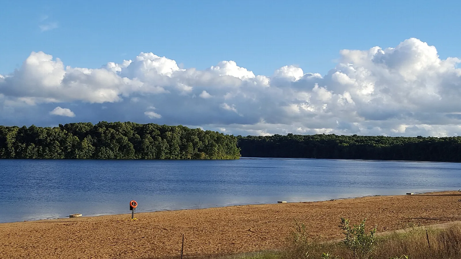 Sandy beach on a lake with forested far shore