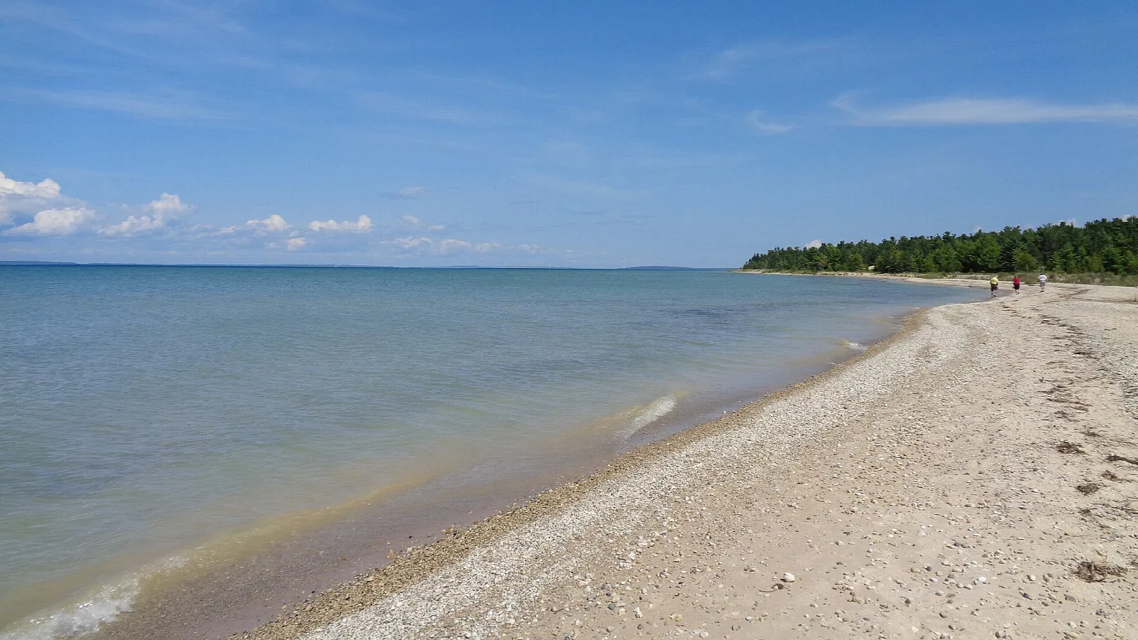 Wide sandy beach along clear blue Lake Michigan water