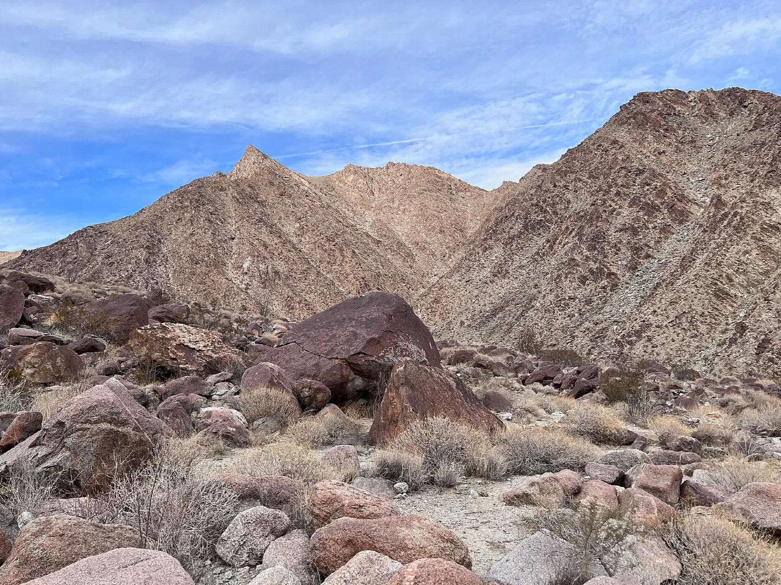 Rocky desert hills and scattered boulders under a cloudy sky