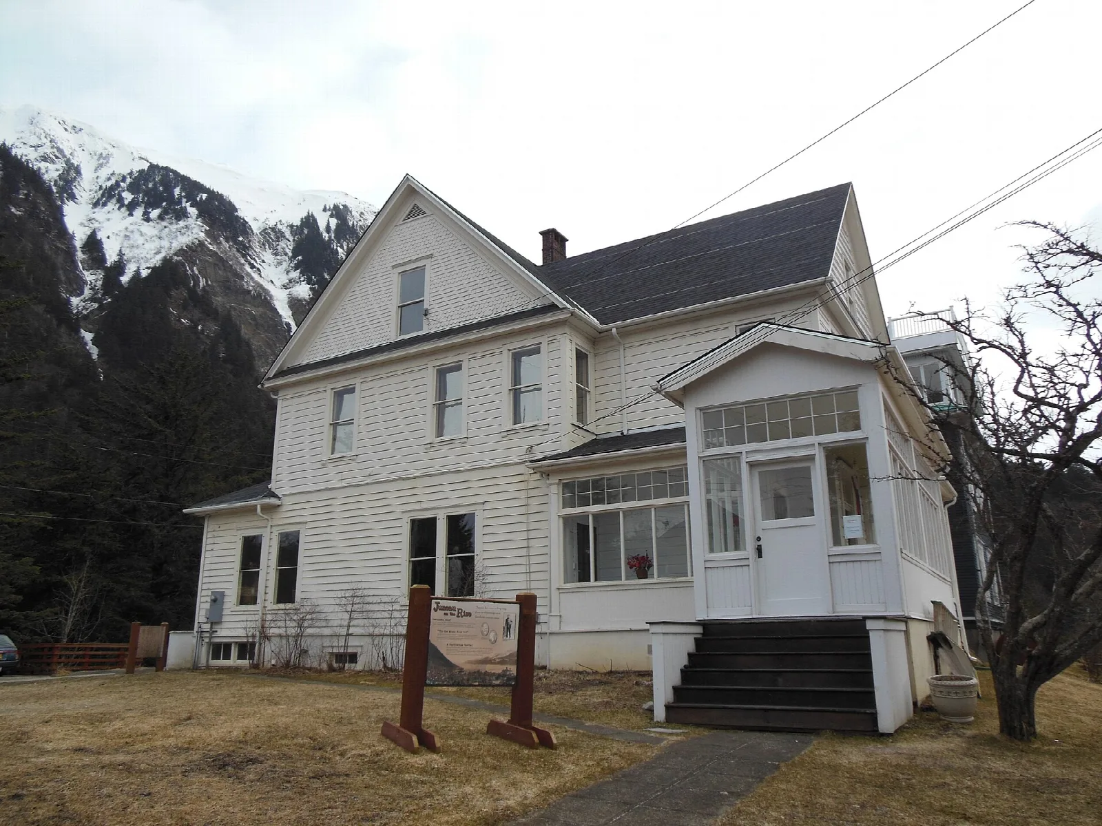 Large white house with a dark roof and a small entry porch