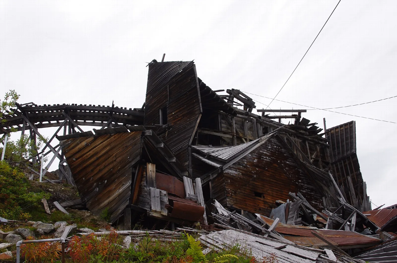 Collapsed wooden mill building and rail trestle