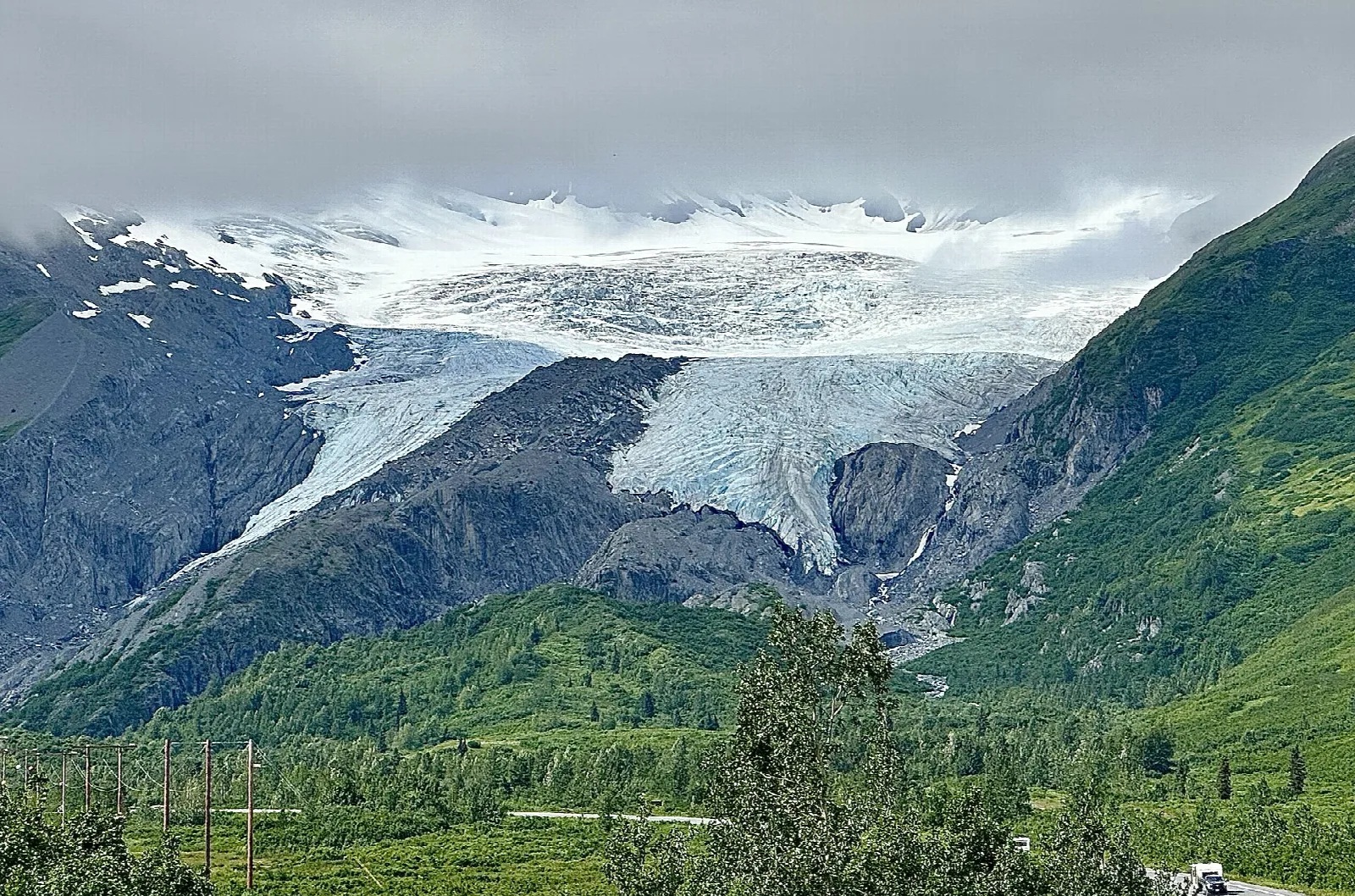 Glacier and snow-covered peaks above a green valley