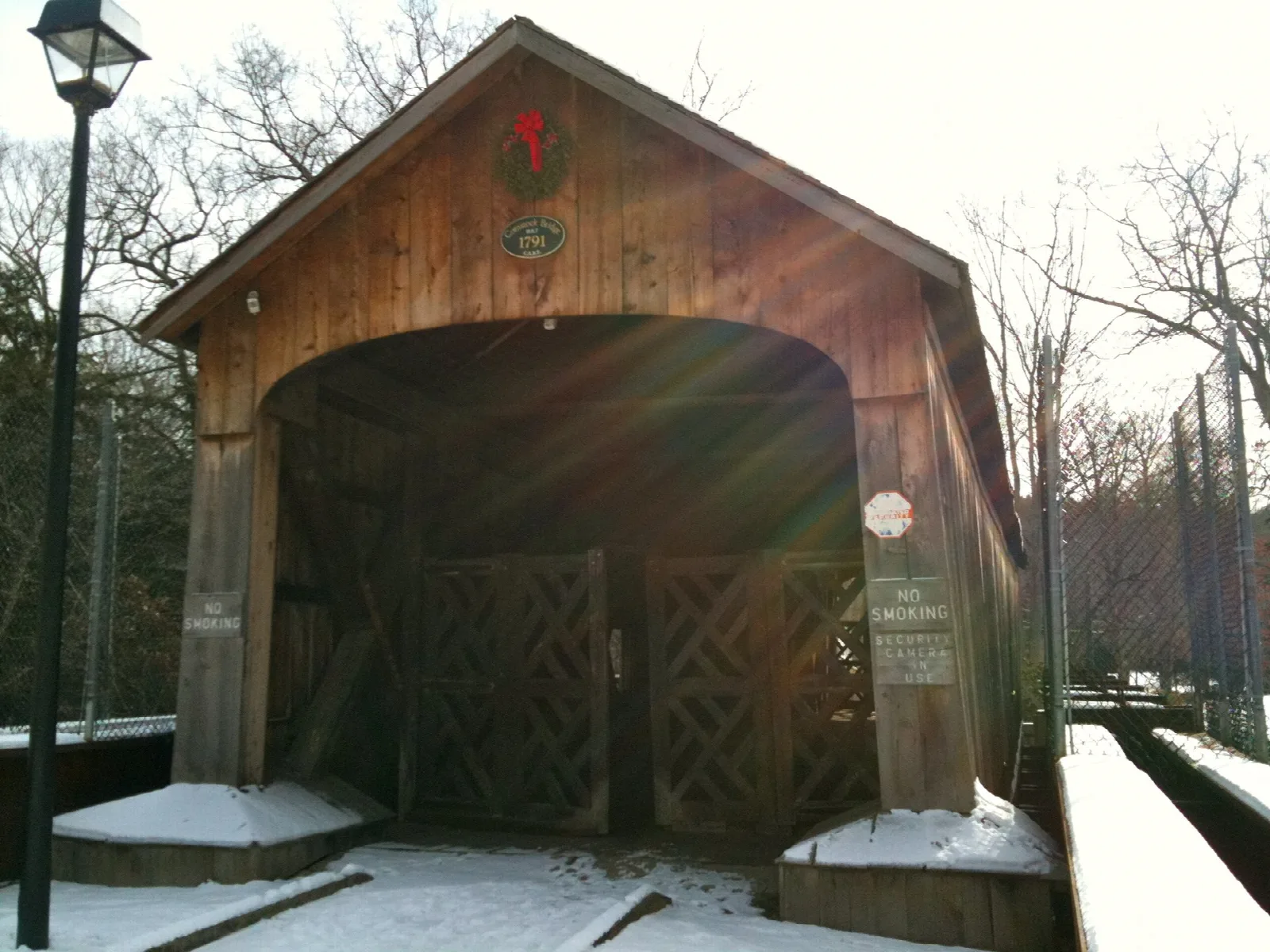 A wooden covered bridge dusted with snow
