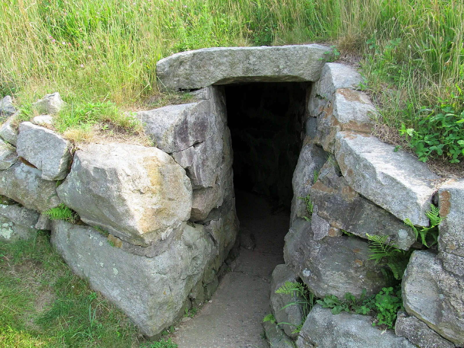 Stone-lined passage entrance in a grassy bank