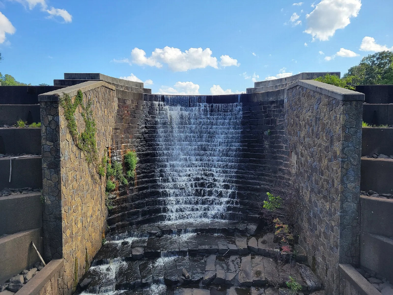 Water spilling down a stone dam spillway
