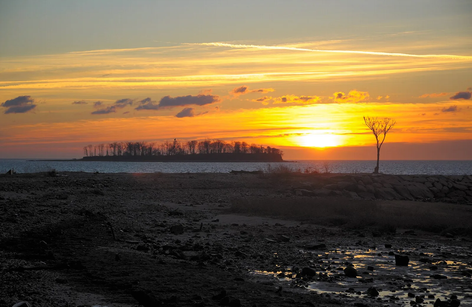 Sunset over a wooded island and dark shore