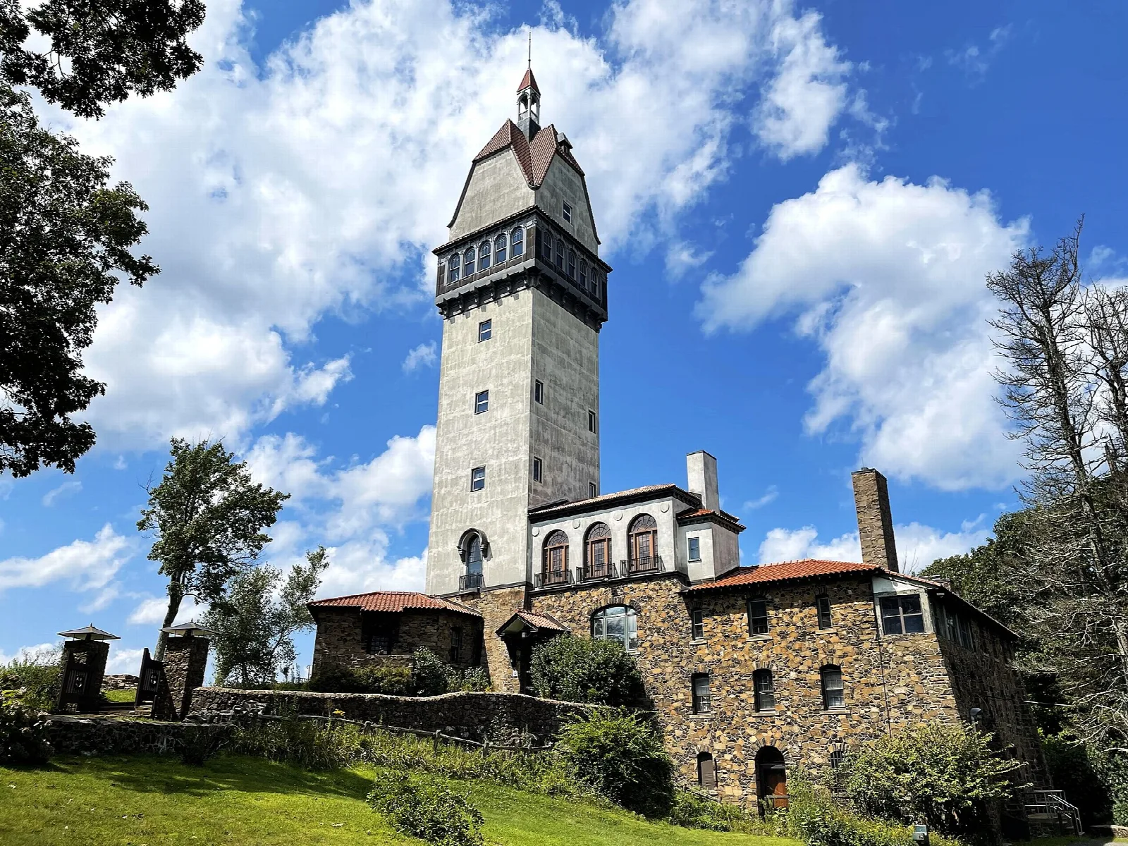 Tall tower with a stone lodge under blue sky