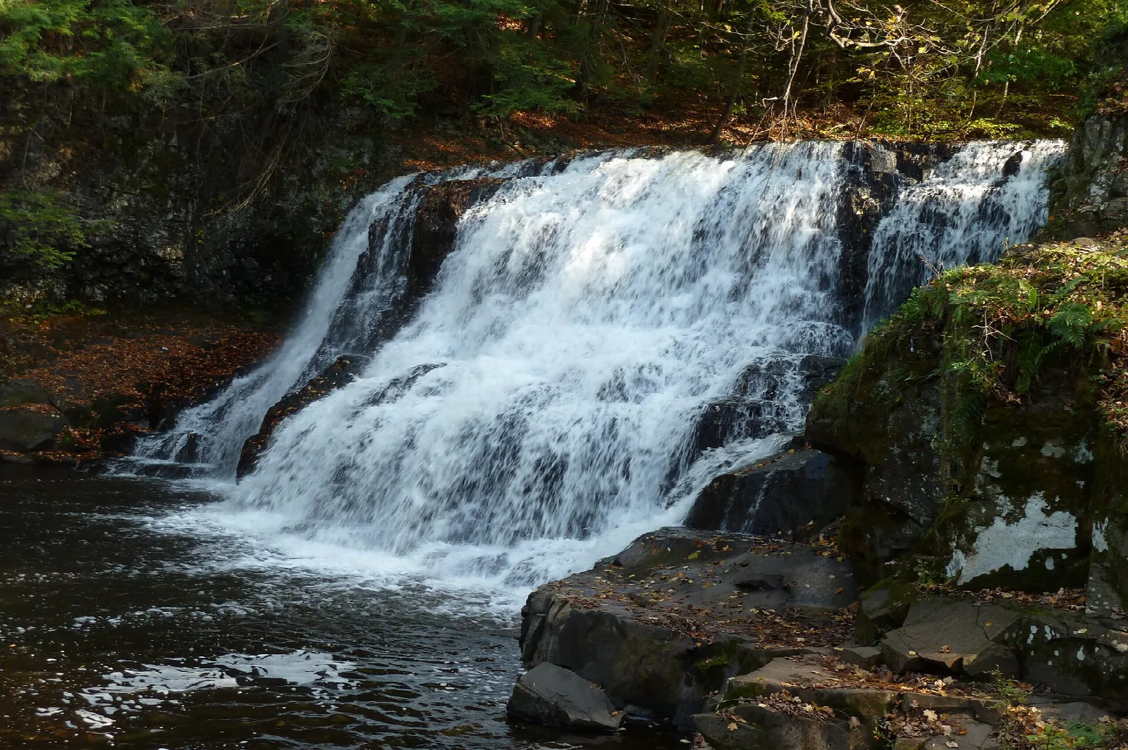 Waterfall rushing over dark rocks