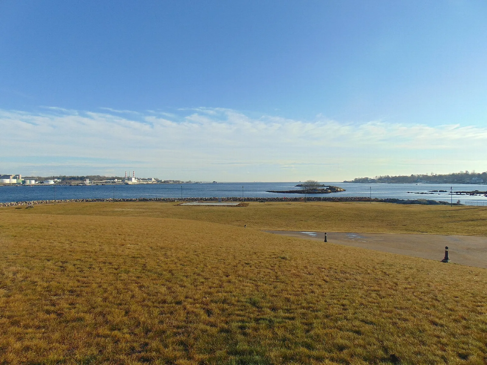 Golden grass field sloping down to the Thames River