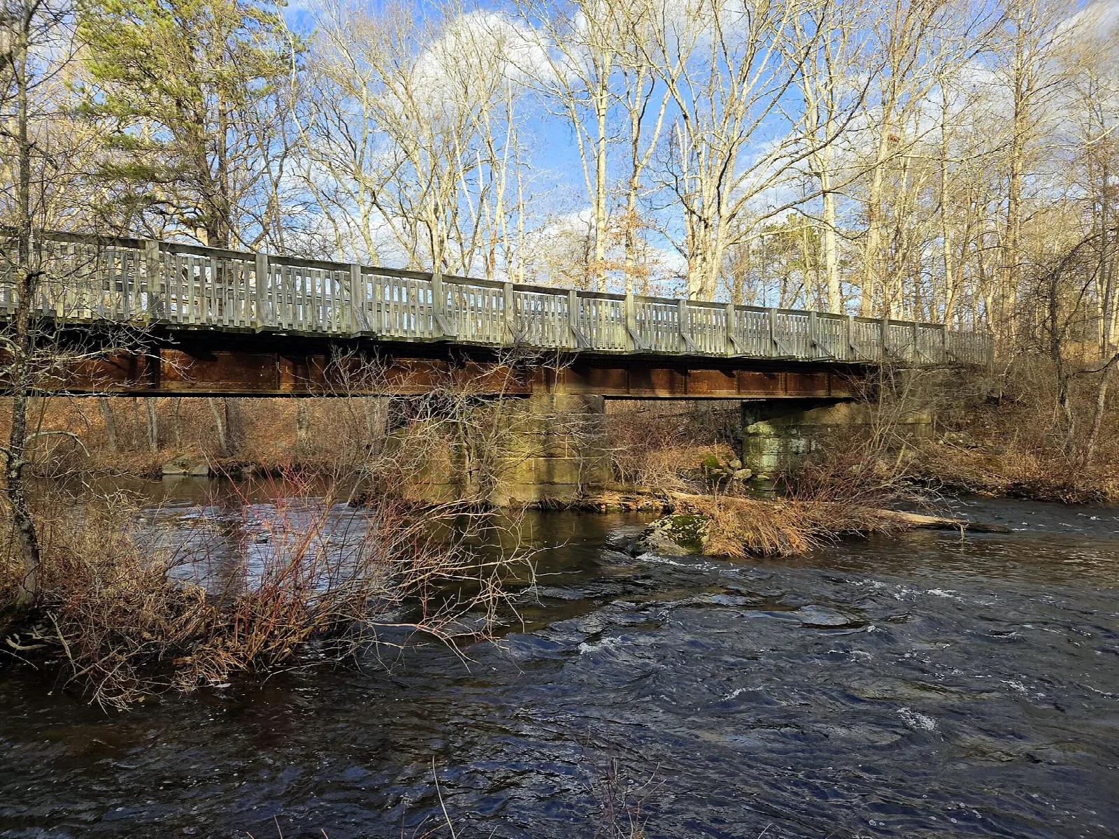Old bridge crossing the Hop River with bare trees around
