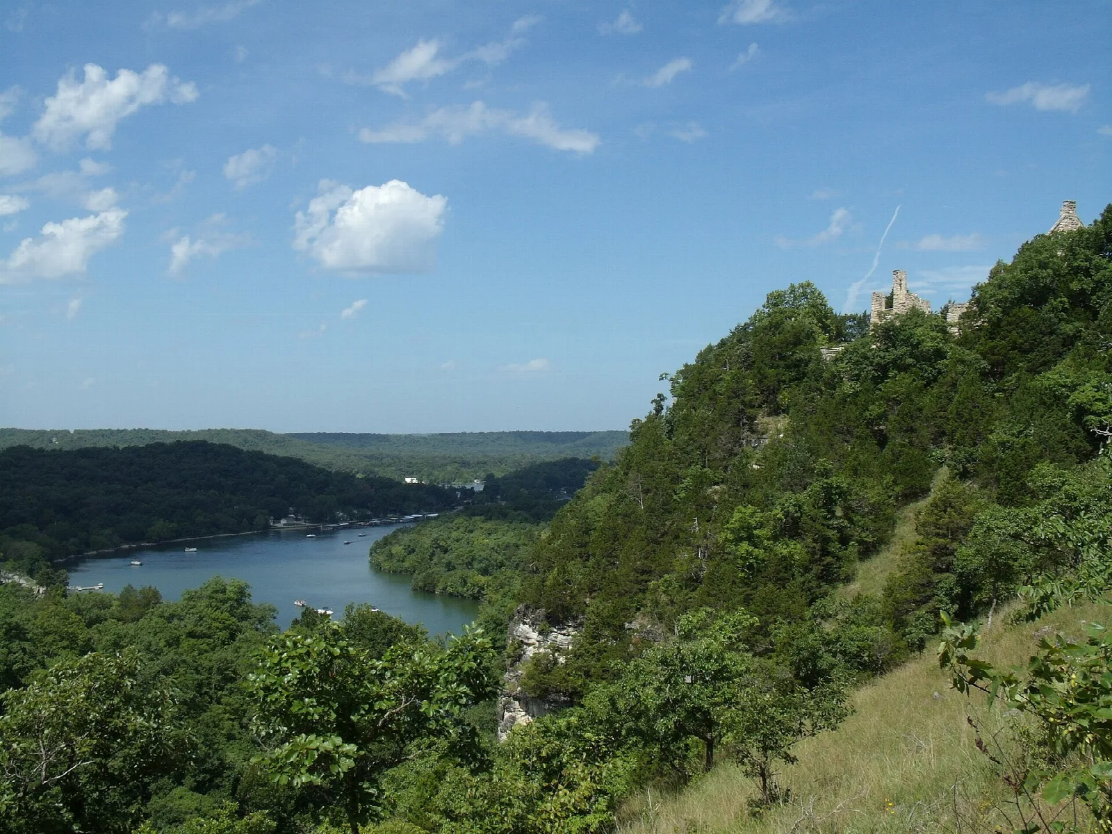 Wooded bluff above a bend of the lake under blue sky