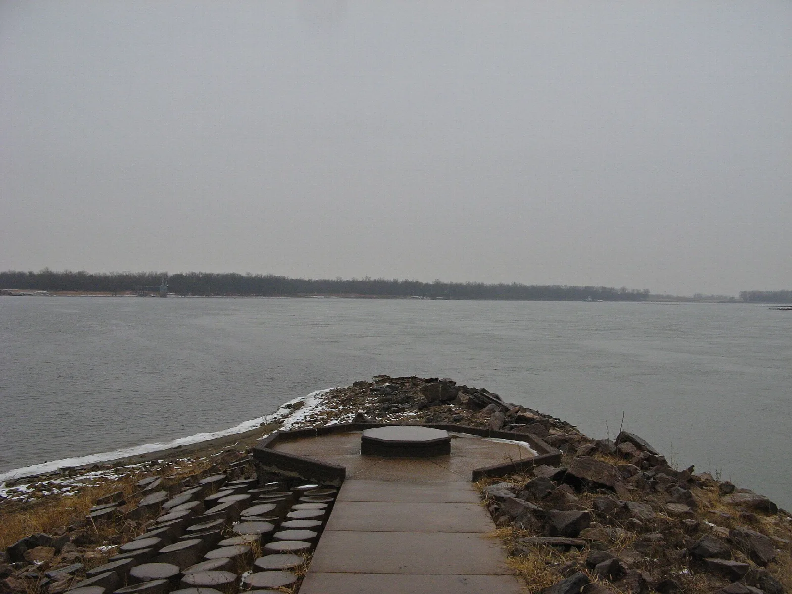Stone-paved walkway leading out to a round platform over the wide river