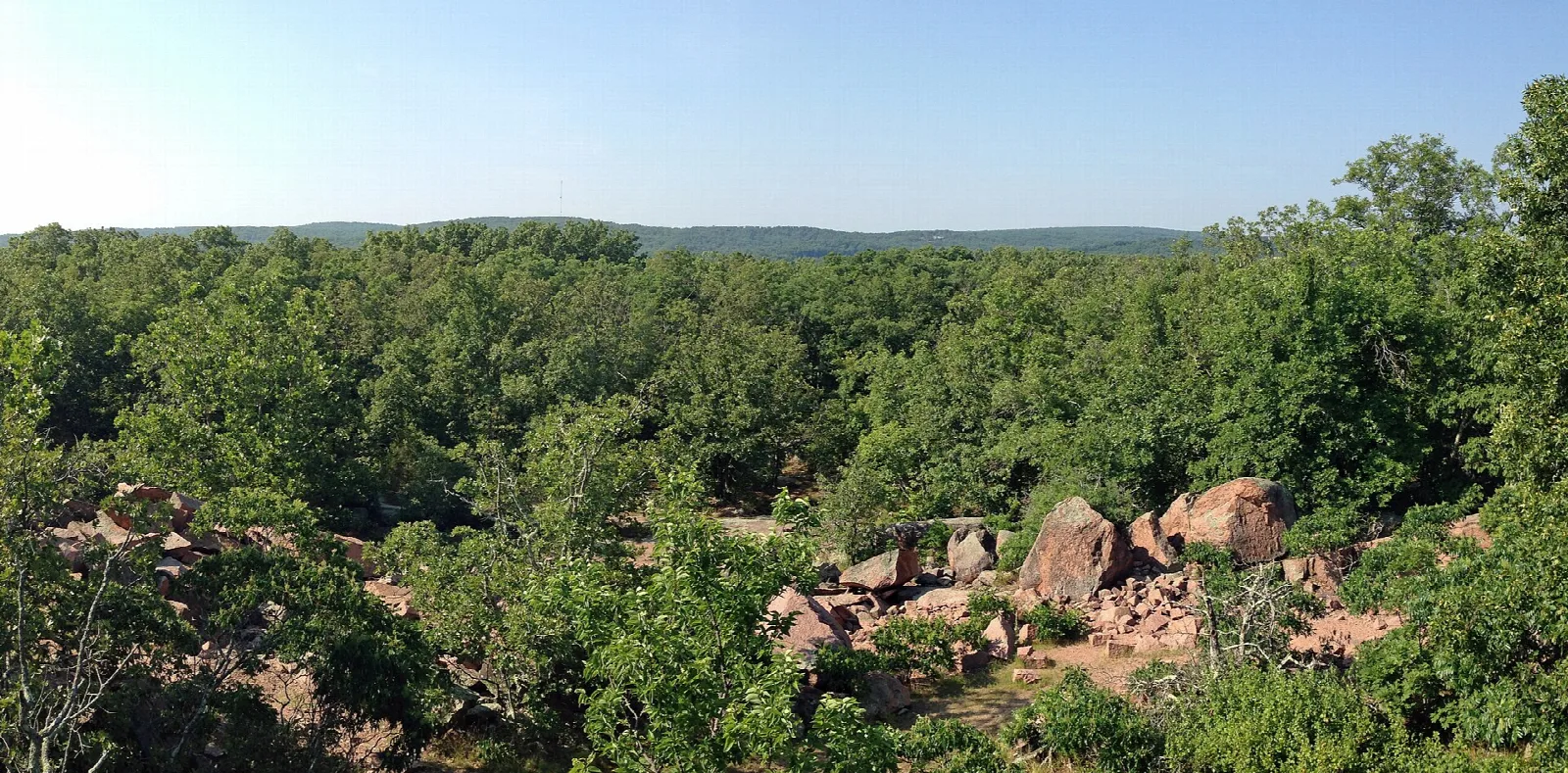 Forested hills with scattered granite boulders seen from an overlook