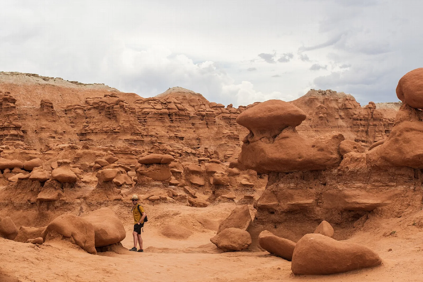 Red sandstone goblins and eroded walls with a hiker standing among them