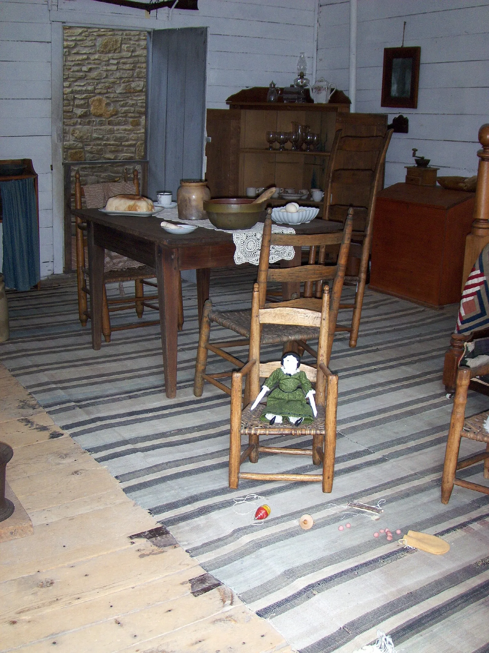 Cabin room with a table, chairs and a striped rag rug