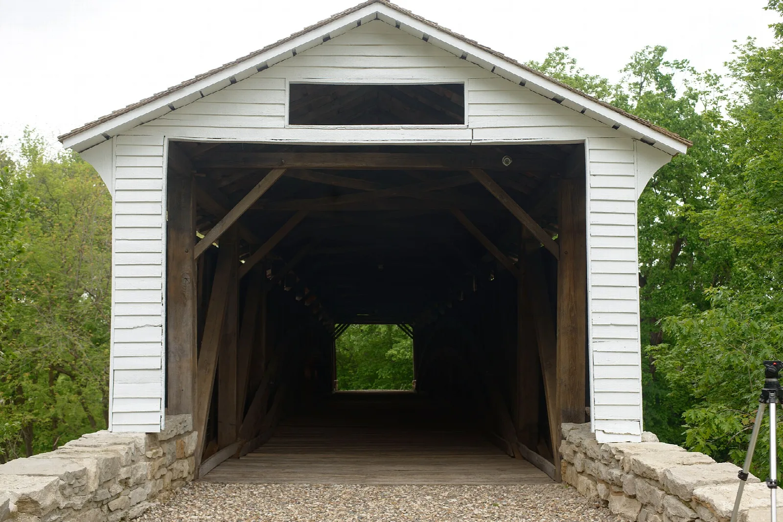 Front view of a white covered bridge portal with stone abutments